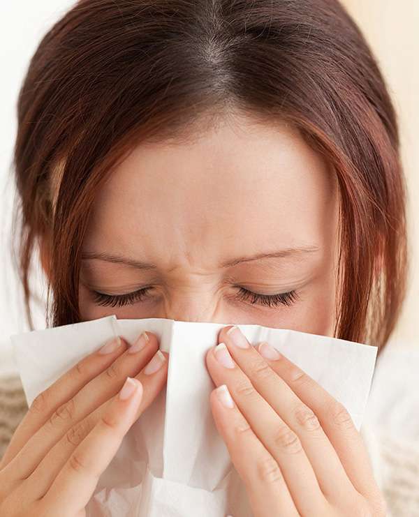 Girl sneezing from common household allergens
